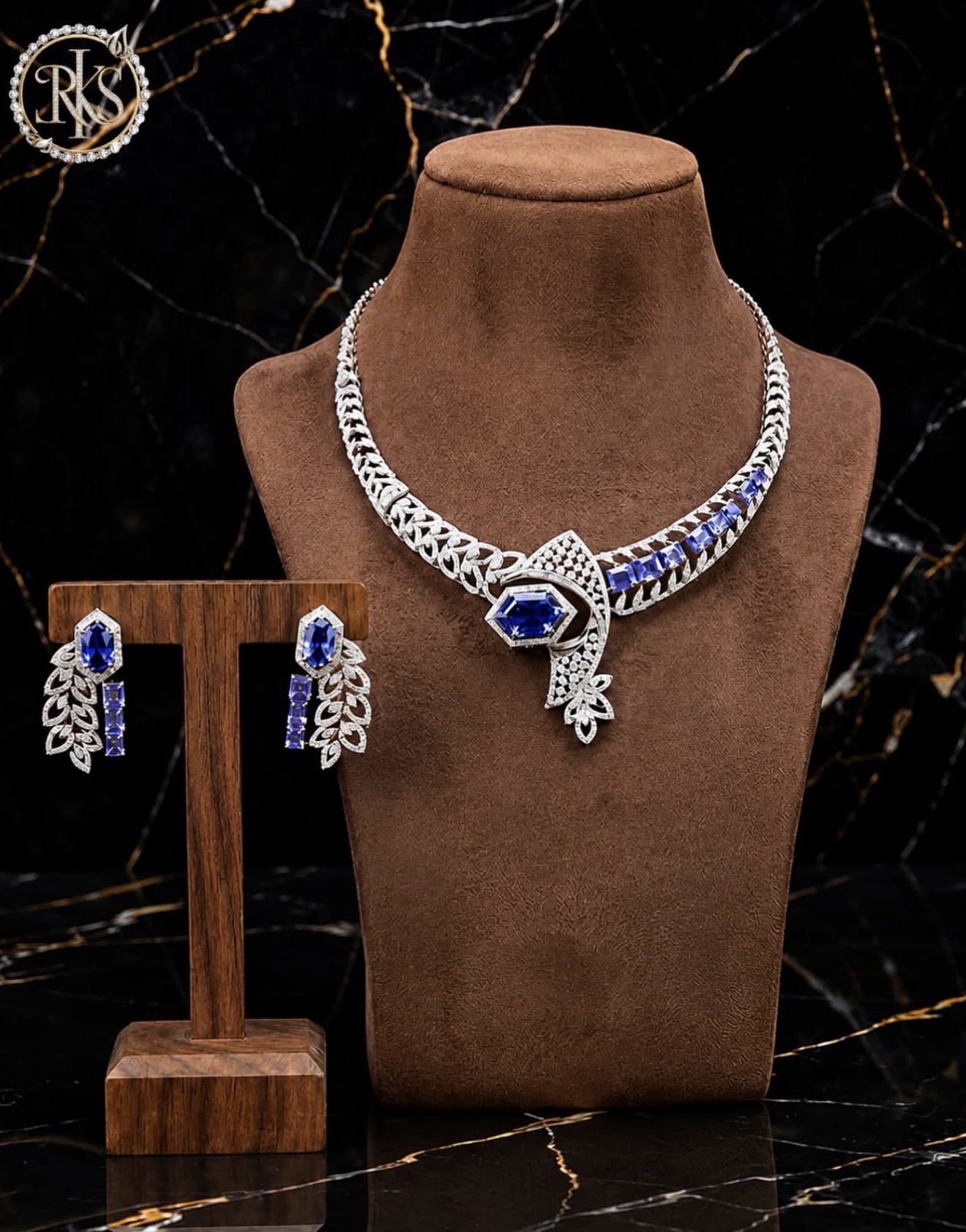 White-gold blue-stone necklace and earring suite on display bust — Ramesh Kapoor & Sons Jewellers