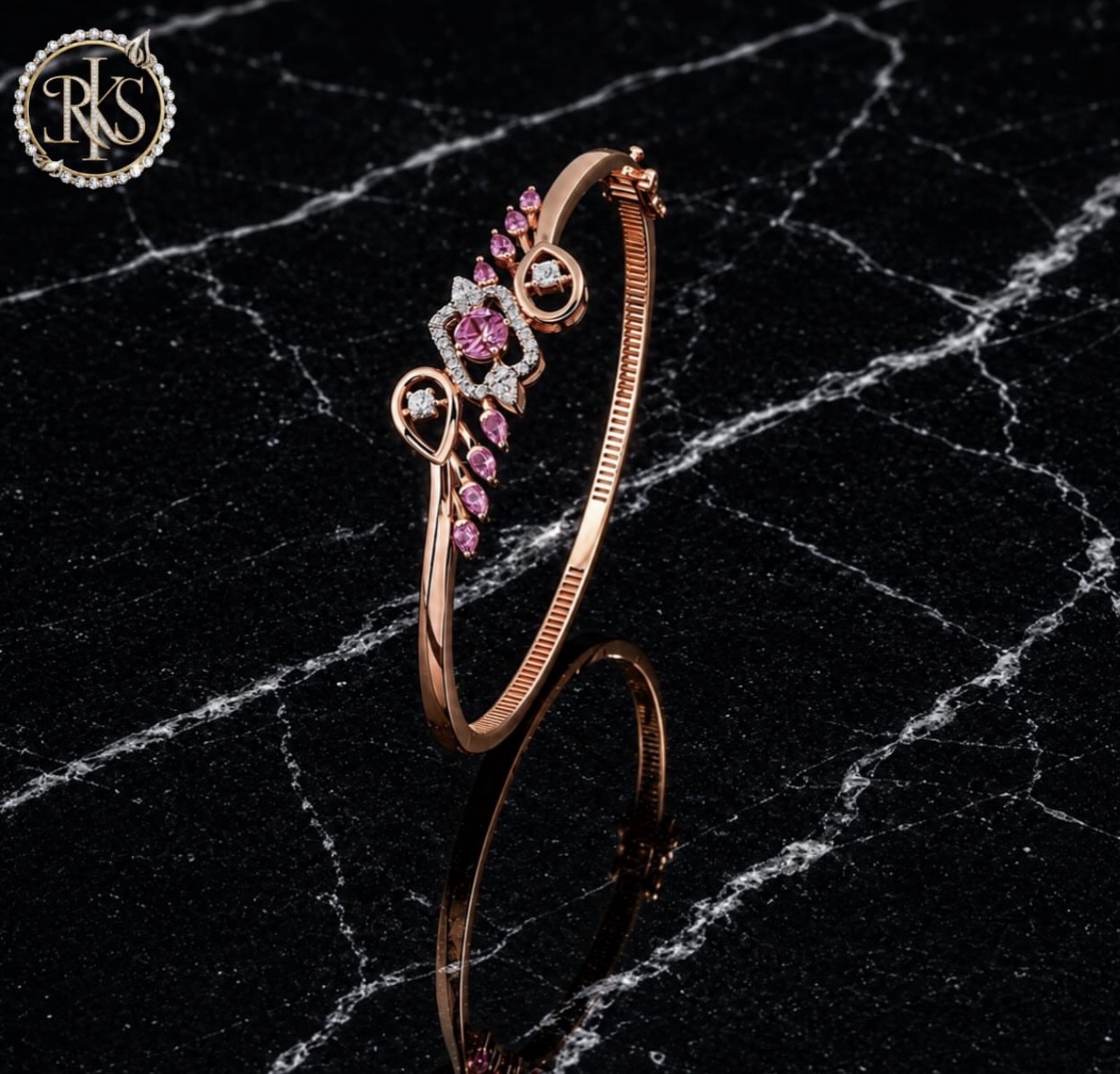 Rose-gold bangle with pink stones and diamond accents on dark marble — Ramesh Kapoor & Sons Jewellers