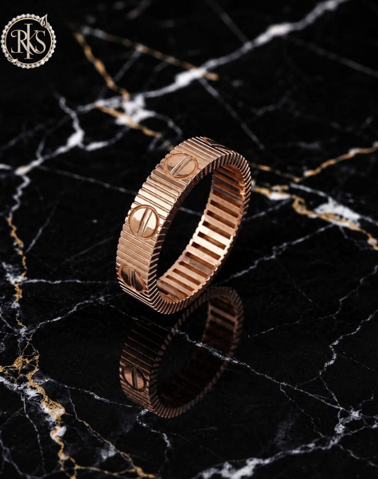 Rose-gold screw-motif bangle on dark marble — Ramesh Kapoor & Sons Jewellers